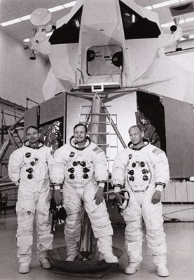 Lot 49 - NASA PHOTOGRAPHER | The 'Apollo 11' crew in front of a mock-up of the Lunar Excursion Module, Kennedy Space Center, Florida, June 1969